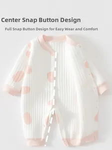 Détail de fermeture à pressions et pois roses sur un body bébé en coton gaufré