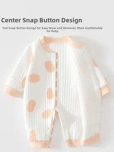 Detail of baby quilted romper with snap buttons and orange polka dots on rib fabric