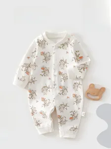 Detail of baby onesie featuring rabbit flower prints and snap buttons on soft cotton fabric