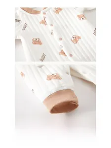 Detail view of cotton quilted baby romper showing resin snap buttons and bear print