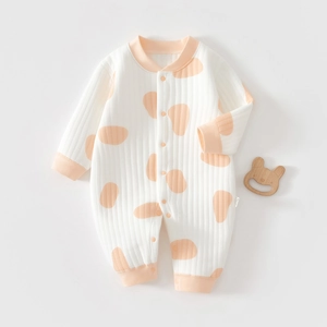 Detail of baby romper with pink polka dots and soft ribbed fabric texture