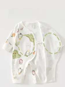 Détail d'une barboteuse en coton pour bébé avec imprimés dinosaures et liens de côté
