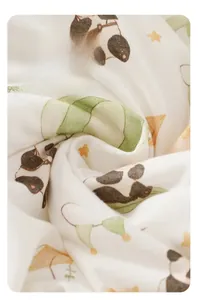 Detail of soft baby cotton fabric with panda and hot air balloon prints in cream white