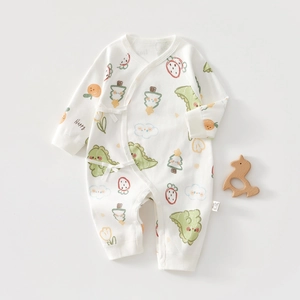 Détail d'une combinaison bébé en coton avec motifs dinosaures et fermeture à nouer