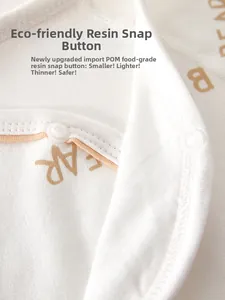 Detail of food-grade POM resin snaps on soft cotton newborn bodysuit with BEAR print