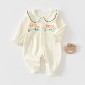 Close-up of baby romper featuring a wavy green collar and hand-drawn flower details