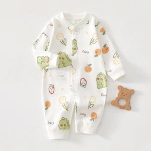 Detail of baby cotton onesie with cartoon dinosaur and fruit prints and snap closure