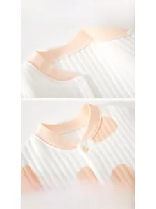 Detail of baby bodysuit featuring ribbed cotton fabric with polka dots and resin buttons