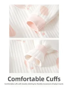 Gros plan de poignets roses côtelés avec double couture sur barboteuse douce pour bébé