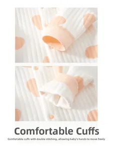 Detail view of elastic ribbed cuffs and double-stitched seams on baby polka dot romper