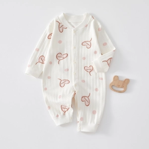 Detail of ribbed cotton baby romper with pink polka dots and heart patterns