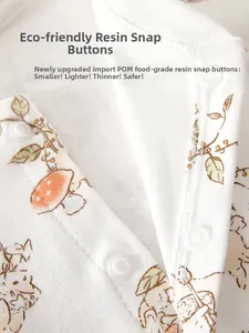 Detail of eco-friendly resin snap buttons on cotton baby bodysuit with forest print