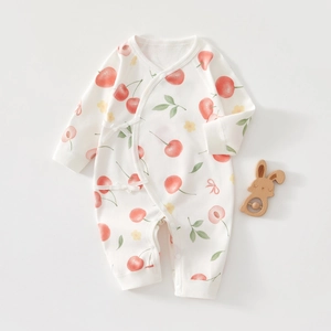Détail du body bébé en coton à manches longues avec imprimés cerises et liens doux
