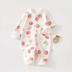 Close-up of cotton baby romper with cherry prints, snap buttons, and size tag