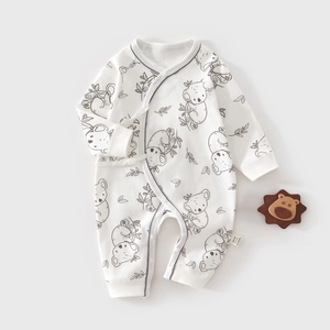 Detail of baby cotton romper with koala print and side-tie closure on light background