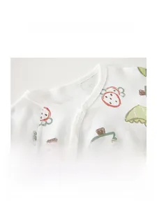 Détail de l'encolure d'un body bébé en coton avec motifs fraises et bouton-pression