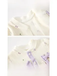 Detail of baby romper neckline with purple bow and cherry print on ribbed fabric