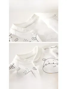 Close-up of baby romper neckline featuring cotton fabric, snap buttons and hippo prints