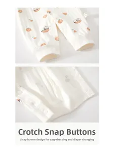 Detail of baby cotton romper featuring snap buttons on crotch and cute panda peach print