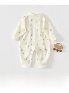 Close-up of baby romper with waffle texture and purple grape patterns in creamy white