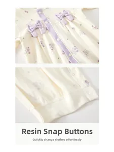 Detail of baby romper featuring purple grape print and durable resin snap buttons