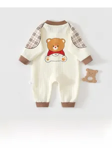 Détail d'un barboteuse pour bébé avec motif ours, manches à carreaux et anneau de dentition