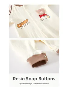 Détail des boutons-pression en résine sur barboteuse bébé en coton avec broderie ours