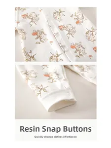 Detailed view of the resin snap buttons on a cotton baby romper with rabbit prints