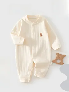 Détail d'une grenouillère bébé en coton côtelé doux avec broderie d'ourson délicate