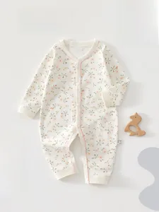 Détail d'une grenouillère bébé en coton à fleurs avec boutons-pression et bords doux