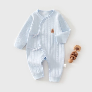 Detail of light blue cotton baby bodysuit with embroidered bear and kimono style closure