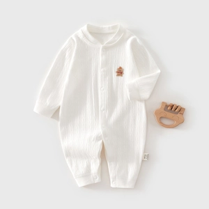 Detailaufnahme von weißem Baby-Strampler aus Rippbaumwolle mit Bärenstickerei und Knöpfen