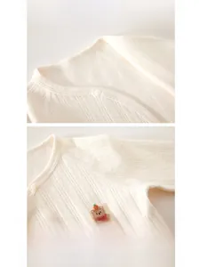 Detail of baby cotton onesie featuring soft ribbed texture and cute bear embroidery patch