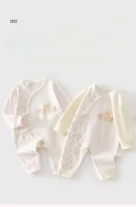 Dettaglio di tutine per neonati in cotone con fiori e orsetti, trama morbida e lacci