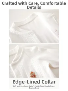 Detail eines weißen Baby-Strickstramplers mit Bärenstickerei und geripptem Kragen