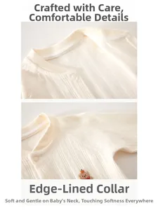 Détail de combinaison en coton pour bébé avec texture côtelée et broderie d'ours