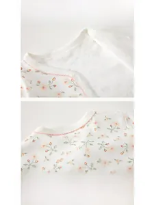 Détail d'un body bébé en coton avec décolleté à imprimé floral et coutures d'ourlet sûres