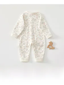 Gros plan sur un barboteuse bébé en coton avec délicats imprimés floraux roses