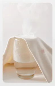 Breathability test of soft cotton newborn jumpsuit showing steam through floral fabric