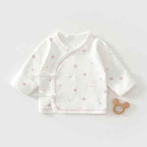 Detail of newborn cotton wrap shirt with delicate pink floral print and lace trim
