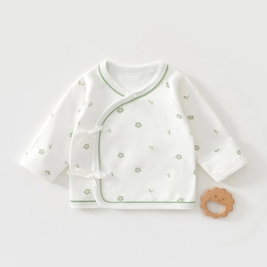 Detail of newborn cotton kimono top with green floral prints and side tie closure