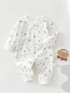 Détail d'une barboteuse en coton pour bébé avec imprimé floral et liens croisés