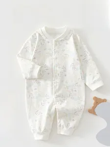 Detail of pure cotton long-sleeved baby romper with delicate floral pattern on soft white fabric
