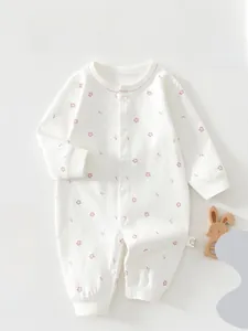 Detail of pure cotton baby romper with floral prints and front button closure