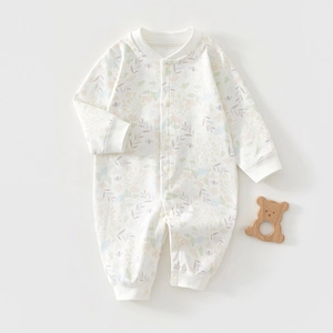 Detailed flat lay of floral cotton baby romper with rib knit cuffs and wood toy decor