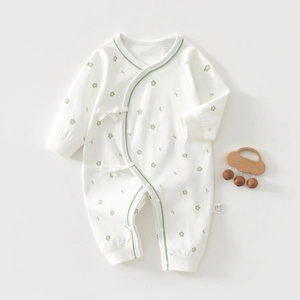 Detailed close-up of newborn floral cotton romper with green trim and side snap buttons
