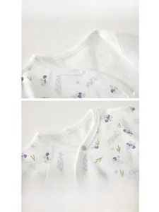 Détail de l'encolure du barboteuse avec bouton pression et imprimé baies sur coton doux