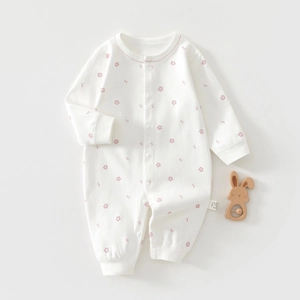 Detail of baby cotton romper with pink floral print and washing label for newborns