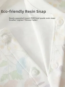Detail of eco-friendly resin snap buttons on soft floral cotton newborn baby romper