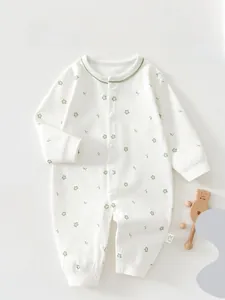 Detailed close-up of newborn floral cotton romper with green trim and snap buttons
